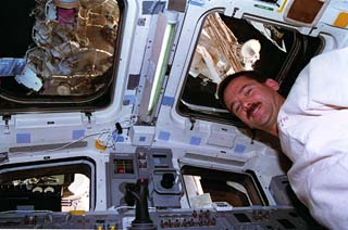  Hadfield on flight deck, Shuttle-Mir docked in window 